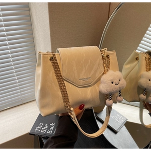 Detail of off-white shoulder bag with marble texture, gold chains, and cloud charm