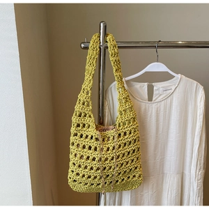 Detalle del bolso tote de ganchillo amarillo calado con una bolsa interior de cuerda