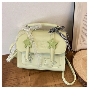 Detail of mint green star messenger bag with lace bows and embossed fashion text