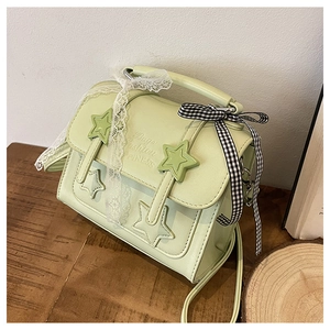 Detail of pistachio green star messenger bag with lace and checkered bow accents