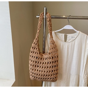 Primer plano detallado del bolso tote tejido caqui con diseño de malla y correa