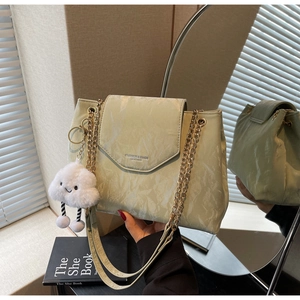 Detail of light green marble texture bag with gold chain and plush cloud pendant