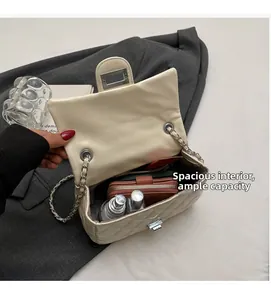 Interior view showing spacious capacity of beige quilted chain bag with various items