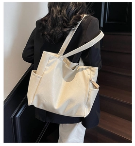 Side view of cream large tote bag with vintage texture on a shoulder-worn model