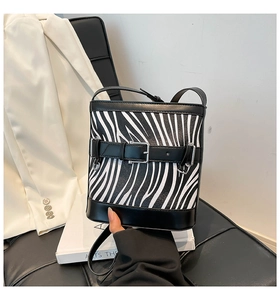 Gros plan du sac seau à motif zèbre avec bordure en cuir noir et boucle en métal argenté