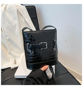 Détail du sac seau noir à motif crocodile avec boucles en argent et finition brillante