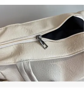 Detailed macro view of the smooth metal zipper and leather texture of the tote bag