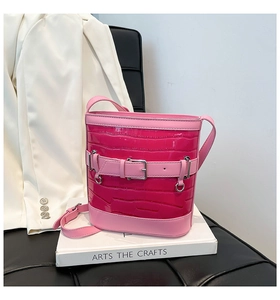Détail du sac seau fuchsia à motif crocodile avec boucle en métal et fini brillant