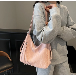 Detailed side view of light pink faux leather shoulder bag with silver zipper and strap