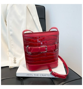 Vue détaillée du sac seau rouge en cuir verni gaufré crocodile avec boucle décorative