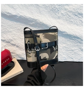 Vue latérale du sac seau camouflage avec finitions en cuir sur fond blanc texturé
