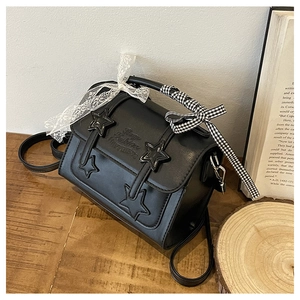 Detail of black star messenger bag with lace bows and vintage star patterns