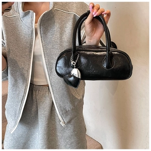 Détail du sac bowling en cuir verni noir avec pendentif cœur et logo Fashion Bags