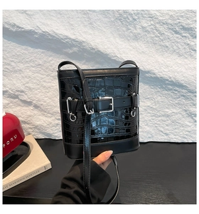 Détail du sac seau noir motif crocodile avec boucles métalliques argentées