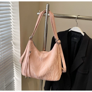 Close-up of light pink tote bag featuring wrinkled texture and decorative zipper detail