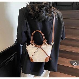 Detail of vintage bucket bag featuring contrast leather trim and bow knot detail