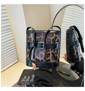 Détail du sac seau imprimé léopard avec bordure en cuir noir et boucle métallique élégante