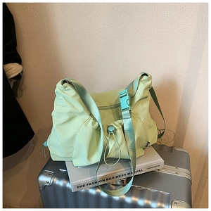 Detail of mint green nylon tote bag featuring adjustable buckle and stylish pleated fabric