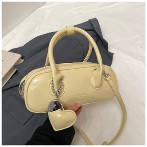 Détail du sac bowling jaune clair avec pendentif coeur et imprimé tendance