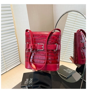 Détail d'un sac seau rouge effet crocodile avec boucle argentée et fini brillant