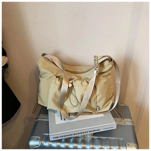 Detailed view of the nylon tote bag with side drawstring pocket and adjustable strap