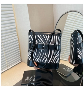 Détail du sac seau à motif zébré avec boucle de ceinture noire et finition en PU lisse