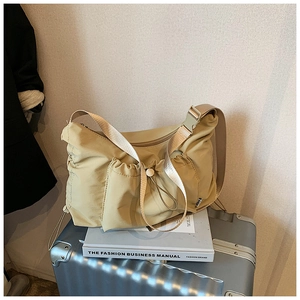 Detail of beige nylon crescent tote bag with functional buckle and adjustable wide strap