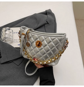 Detail of silver quilted crescent bag with gold twist lock and chunky chain strap