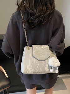 Silver metallic pleated shoulder bag with gold chain strap and cloud plush pendant
