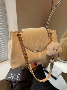 Chic beige faux leather shoulder bag with marble texture and gold chain strap in a cozy room
