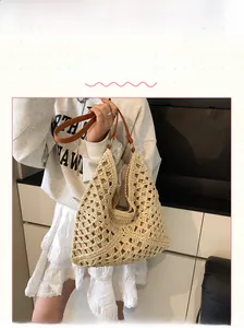 Detail of hollow out straw tote bag with brown leather straps and beige crochet pattern