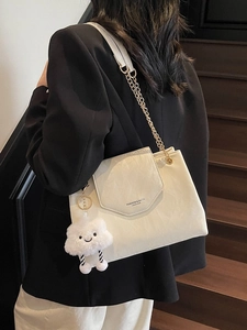 Creamy leather shoulder bag with gold chain strap and cute cloud charm on model
