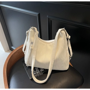 Detail of off-white pleated leather shoulder bag with silver rings and long zipper pulls