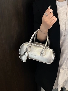 Sac bowling argenté métallisé avec breloque cœur et longues anses sur tenue chic