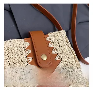 Dettaglio della borsa in paglia fatta a mano con finiture in pelle marrone e fibbia vintage