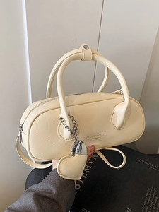 Sac bowling chic jaune crème en cuir verni brillant avec pendentif cœur