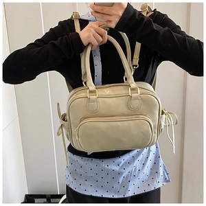 Cream white vintage multi-functional backpack and handbag worn in a casual indoor setting