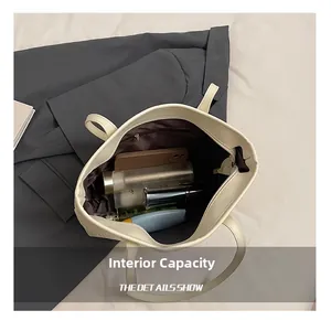 Vue intérieure montrant la grande capacité et la poche zippée du sac fourre-tout crème