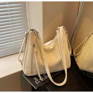 Macro shot of off-white hobo bag showing wrinkled leather texture and silver zipper detail