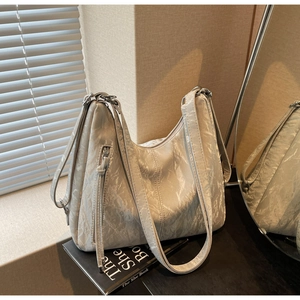 Detail view of marble-patterned tote bag with metallic zipper and side buckle hardware