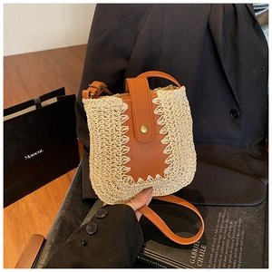 Dettaglio borsa a tracolla in paglia fatta a mano con finiture in pelle a zigzag e fibbia