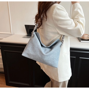 Close-up of light blue textured PU shoulder bag with bold silver chain link strap