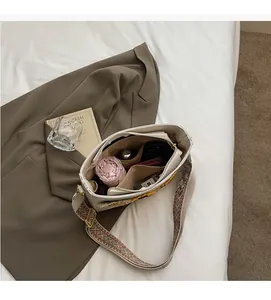 Detail of the bucket bag interior capacity with embroidered strap and everyday essentials