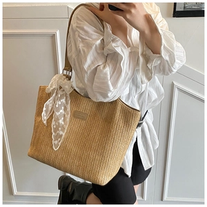 Close-up of woven straw tote bag with herringbone pattern and lace scarf accessory
