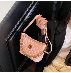 Detailed shot of pink quilted faux leather bag with gold chain and turn-lock closure