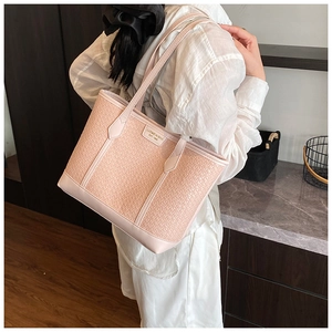 Détail de la texture tissée rose et des lanières en cuir du grand sac fourre-tout