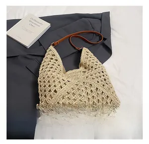 Detailed macro view of beige hollow-out woven tote bag with brown leather strap