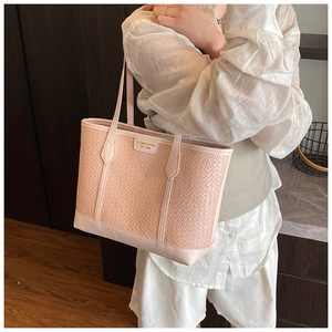 Détail d'un sac cabas rose à texture tissée avec logo métallique et fine bandoulière