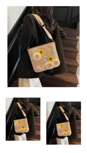 Detail of floral embroidery and woven strap on a beige crossbody bucket bag