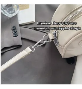 Dettaglio della texture in pelle crema con zip argentata e cuciture rinforzate a mano